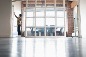 Casual young man writes on white board in hip office conference room, low angle