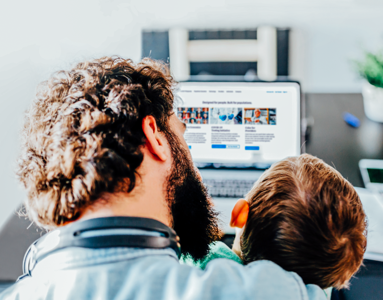 Man and child sitting in front of a computer